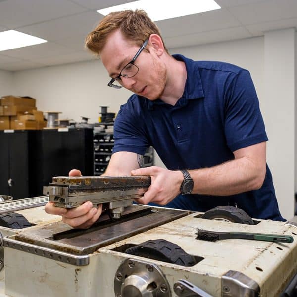 Man observing underside of robot materials