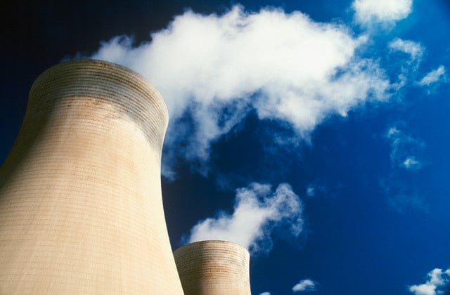 Large cylindrical storage tanks pictured with sky in background