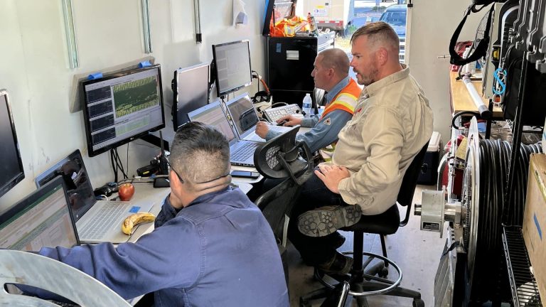 three workers doing research on computers